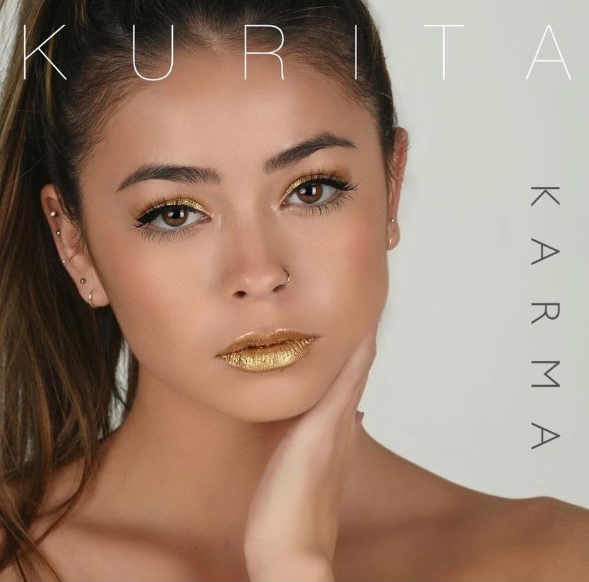 A woman with long hair and gold lipstick.