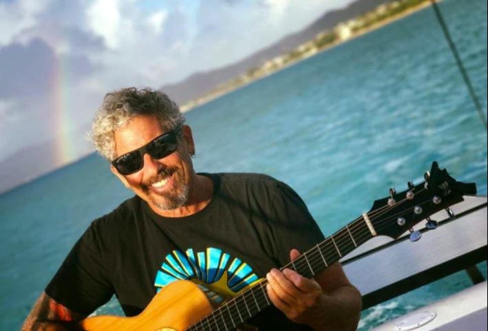 A man playing guitar on the water